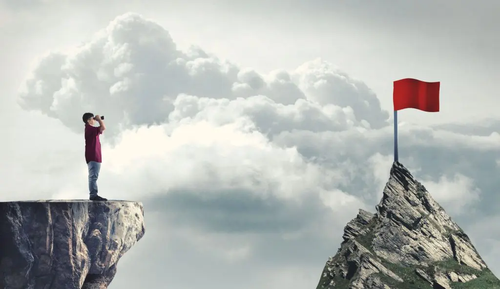 person spotting a red flag from a mountain - illustrating how spotting red flags can help you avoid bad marketing agencies