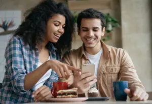 two young adults looking at phone for a blog about website retention