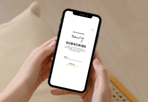 person holding phone with a screen pulled up to sign up for savys enews, for a blog about the email marketing customer journey