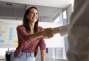 woman shaking someones hand in conference room for a blog about strategic positioning
