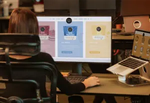 Back of woman sitting in office chair looking at computer screen for a blog about high performance website design
