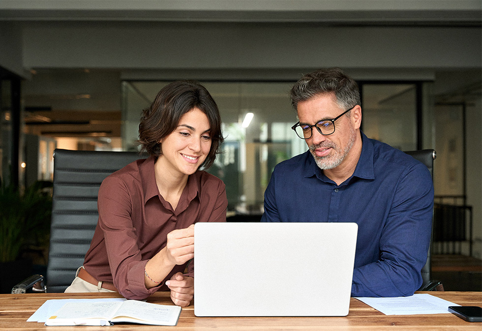 man and woman at conference room table looking at laptop for a blog about how to measure the success of generative engine optimization campaigns
